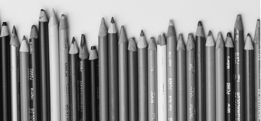 Pencil crayons lined up black and white photo.
