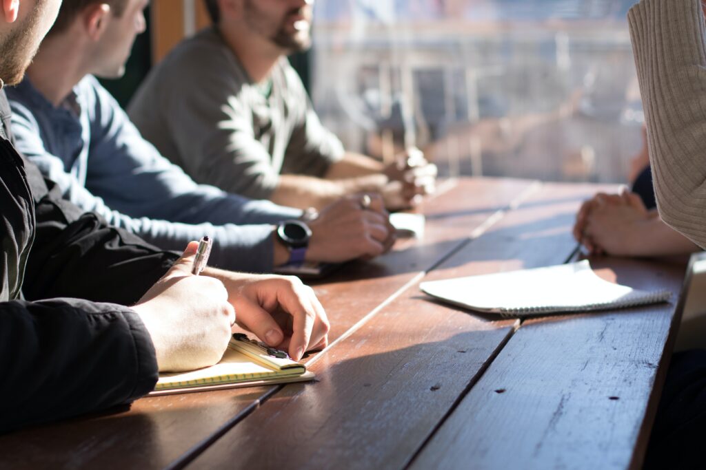 People sitting together on a table with bright sunrays falling over table.
