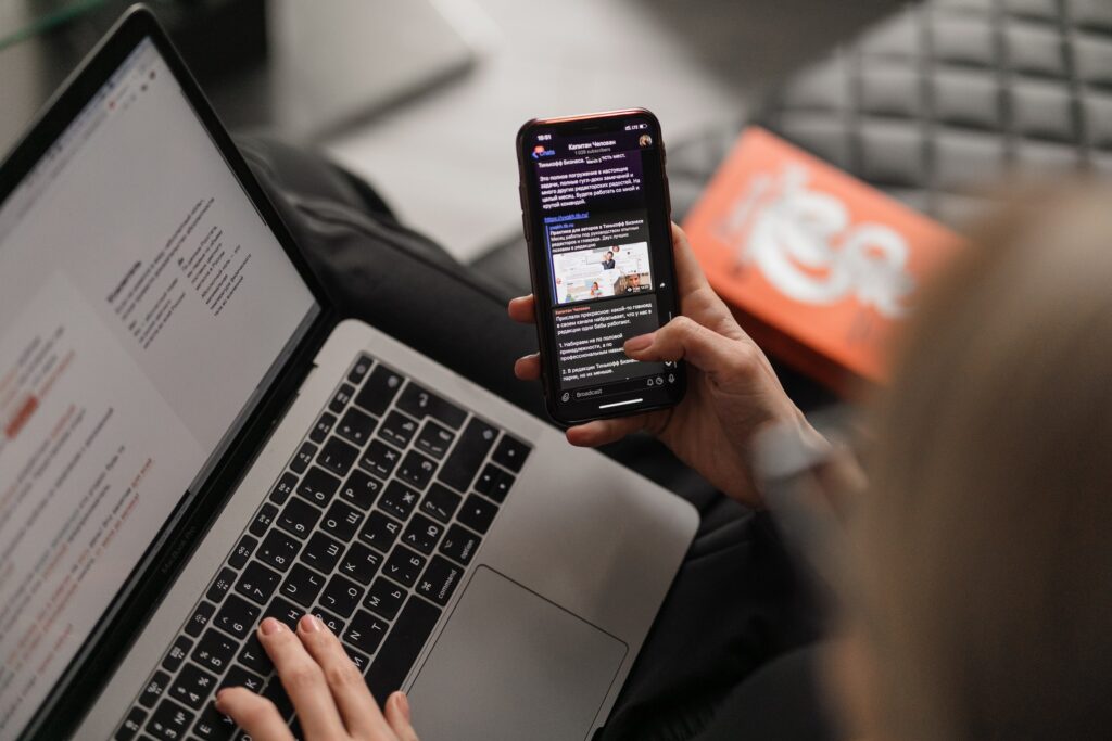 person sending e-mails and using their mobile device