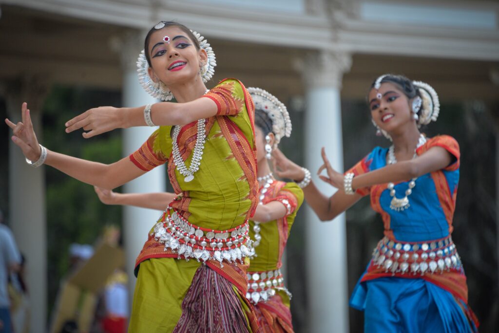 Three girls in Indian dress are dancing