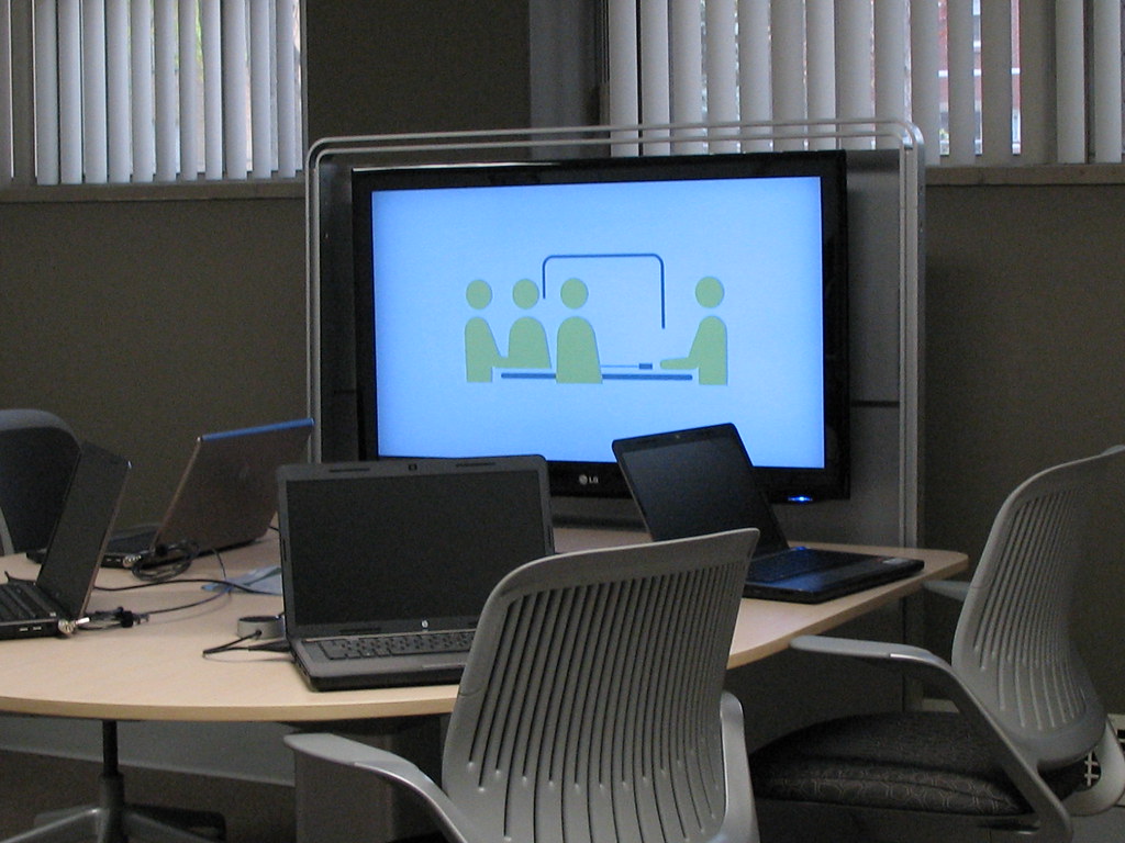 Desk and chair with computer. Icon of group work on the screen.