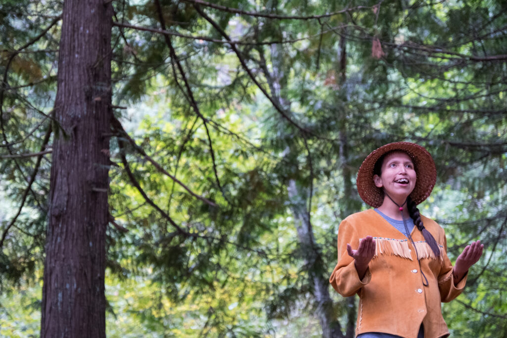 An Indigenous Canadian woman takes time to bless the trees and nature surrounding her. She is pregnant and admiring the beauty in nature.