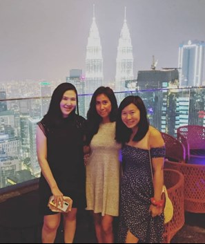 3 friends with the Kuala Lumpur skyline in the background