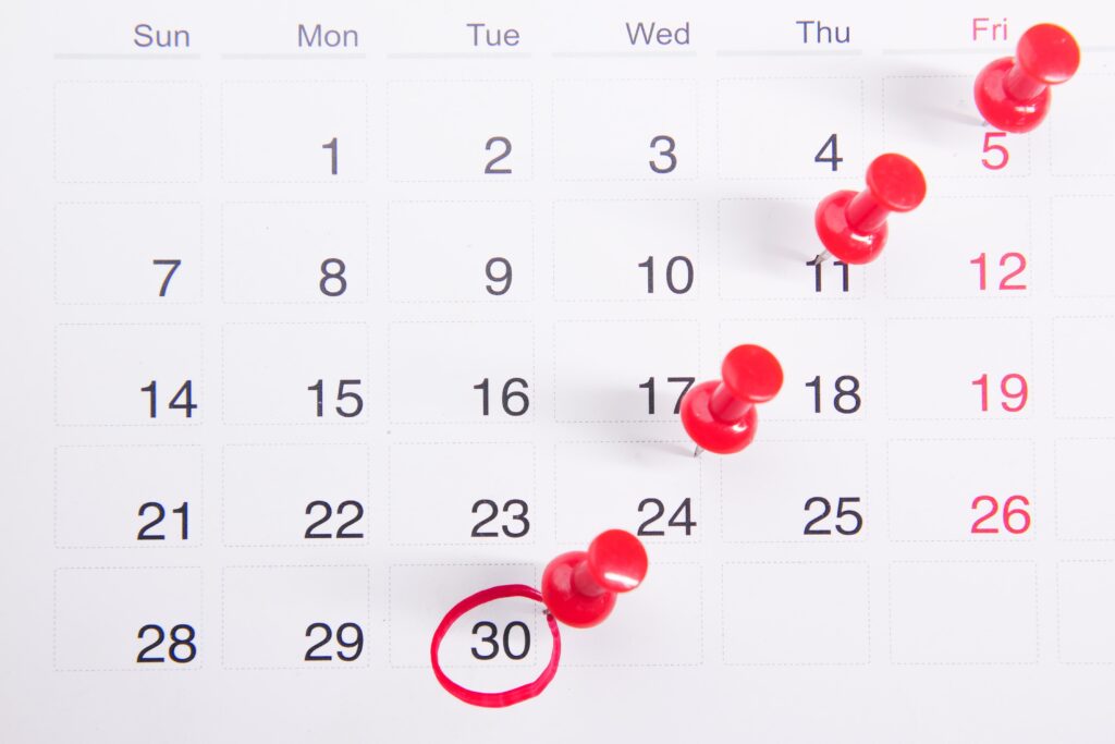 calendar with pushpins on dates and a date circled