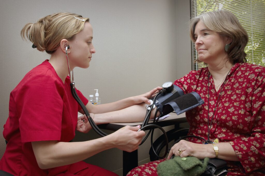 Nurse taking blood pressure of another person