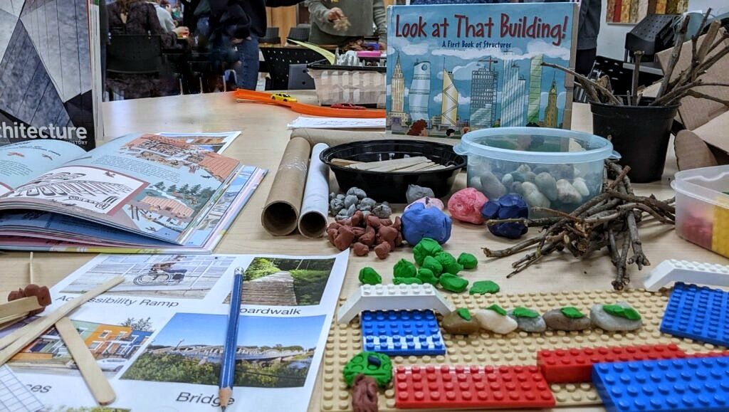 A scene with a variety of objects on a table, lego, papers