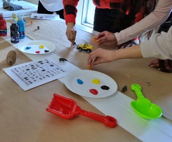 Two Early Childhood Education students work together, using paint and paper plates, to design a play-based early learning program for children.