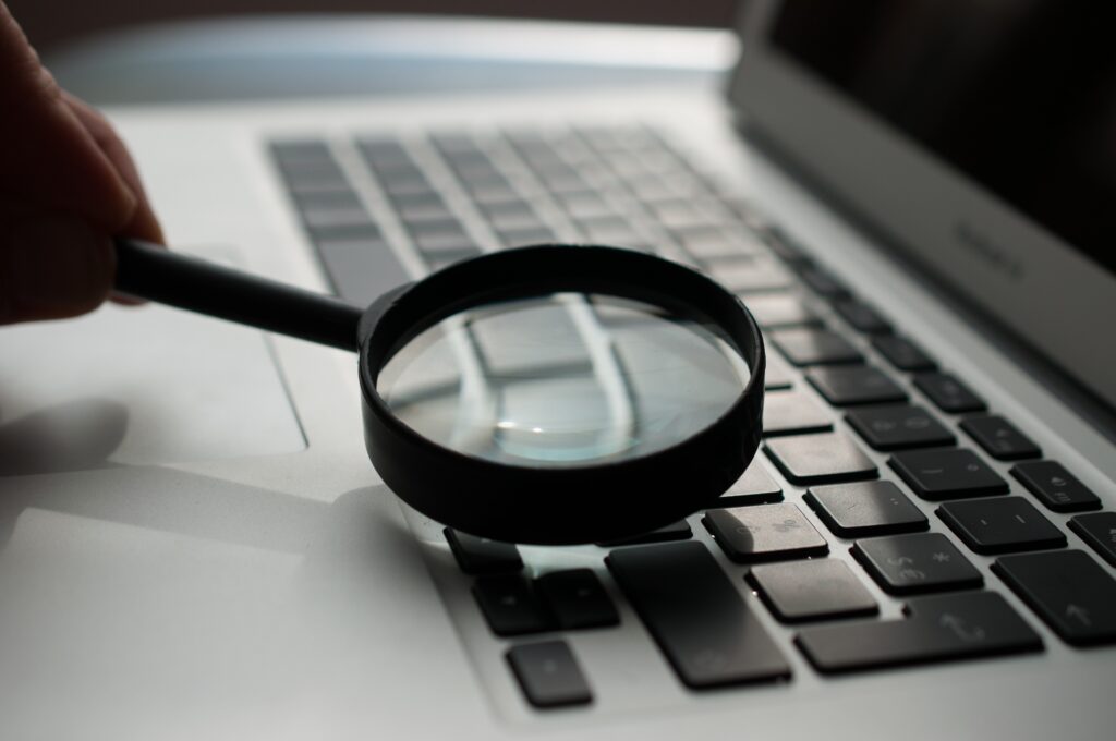 magnifying glass held over a laptop