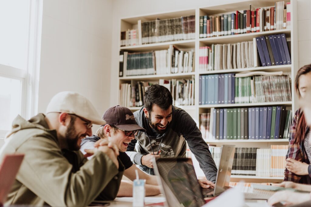 college students collaborating on an assignment, seated at a table in a library