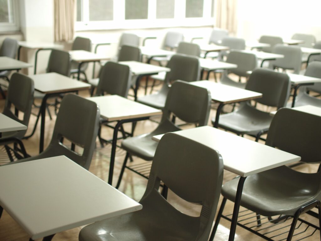 a classroom with empty desks and chairs in rows