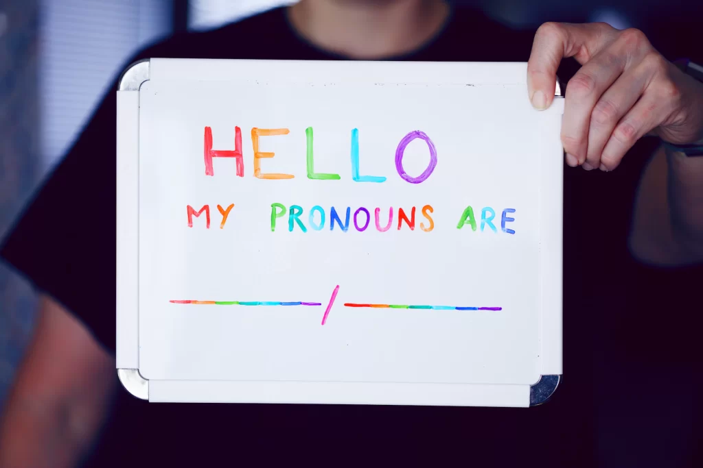 A whiteboard that reads "Hello, my pronouns are ___/___"
